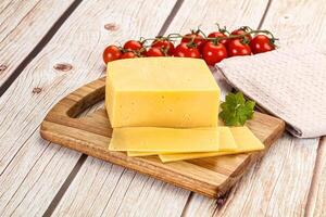 Cheese on a cutting board with tomatoes and herbs photo