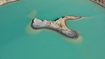 Drone view of the turquoise lake formed as a result of mining waste video