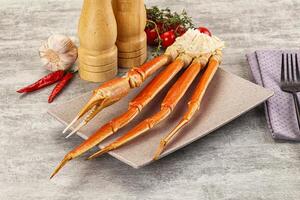 A plate with a crab leg on it and a knife and fork photo