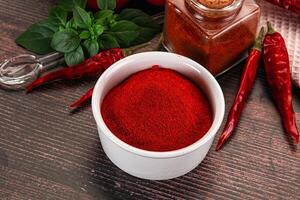 Red chili powder in a white bowl with other spices photo