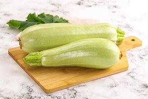 Two green squash on a cutting board photo