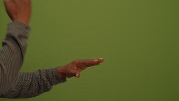 A CloseUp View of a Hand Making Gestures Against a Vibrant Green Background Scene video