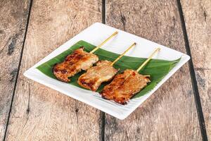 Three skewers on a plate with meat on them photo