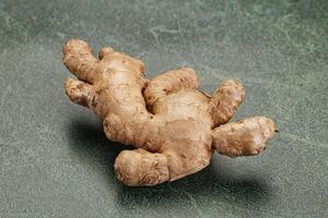 A ginger root on a green surface photo