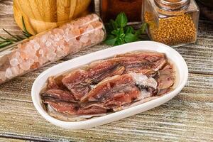 A bowl of meat and spices on a wooden table photo
