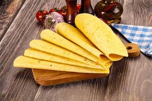 A wooden cutting board with several tortillas on it photo