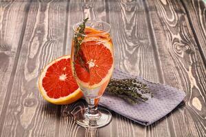 A glass of orange juice and a grapefruit on a table photo