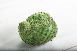 A green fruit on a white surface photo