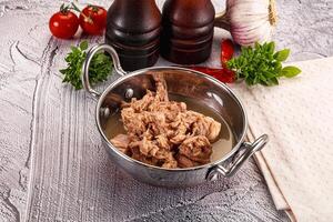 A pan with meat and vegetables on a table photo