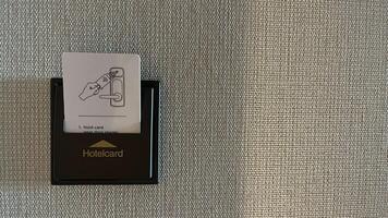 Warsaw, Poland. November 02, 2024. A close-up of a hotel room with a keycard reader. The reader has a small instruction card showing how to use the keycard to unlock the door photo