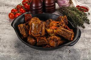 A bowl of meat with vegetables and herbs photo