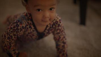 A cute little baby is happily crawling on a soft, cozy carpet, exploring their surroundings video