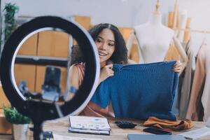 A woman is holding up a shirt in front of a mirror photo