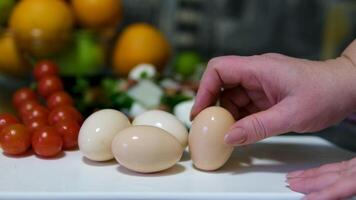 Close-up of female hands peels boiled egg. Peeling eggs from the shell. Cooking dinner or salad with boiled eggs video