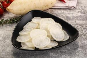 A bowl of sliced vegetables on a table photo