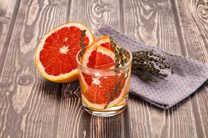 A glass of orange juice and a grapefruit on a table photo