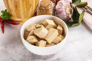 A bowl of tofu and spices on a marble counter photo