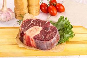 A piece of meat on a cutting board with a knife photo