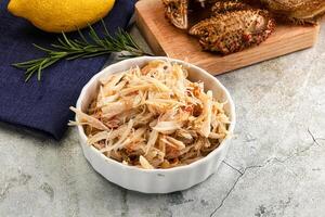 A bowl of food with a lemon and a knife photo