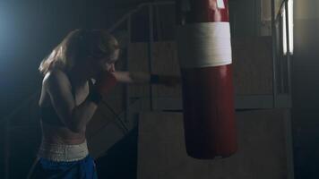An athlete practicing perfect boxing technique, delivering precise and powerful punches on the punching bag. Slow motion video