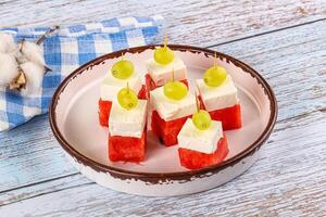 A plate with watermelon slices and cheese on it photo