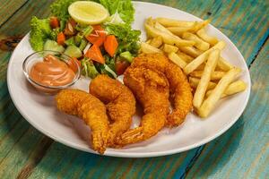 A plate of fried fish and french fries with a salad photo