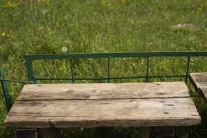 empty old brown table on green grass background. photo