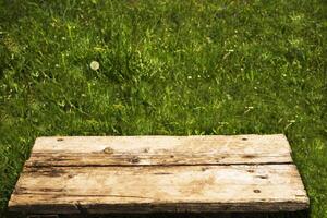 empty old brown table on green grass background. photo