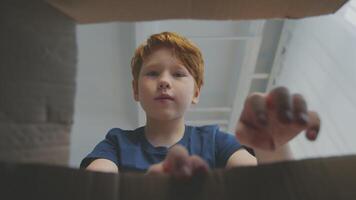 A preteen boy with red hair focuses on his online lesson from a comfortable setting. He is actively participating in remote education, showcasing a modern learning environment. video