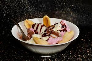Delicious Banana Split Sundae with Chocolate Syrup photo