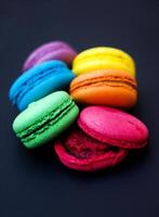 Sweet and colorful french macaroons or macaron on black background. photo