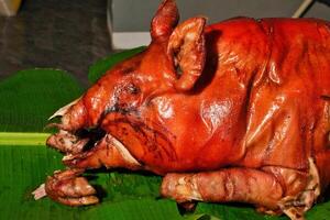 a pig is sitting on a banana leaf photo
