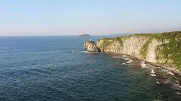 Basargin Lighthouse on a rocky island with a suspension bridge to it. Drone view video