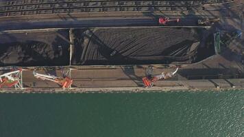 Mooring wall of the port of the sea cargo terminal with port cranes. Drone view video