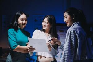 Three women standing in front of a computer screen photo