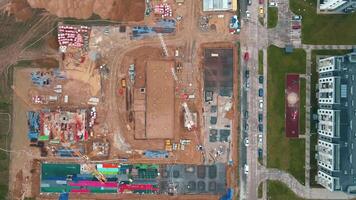 Aerial view of construction site with cranes, foundations and building materials. Residential building under construction. Progress of new development in small town video