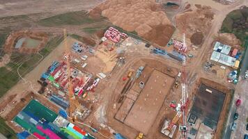 Aerial view of construction site with cranes, foundations and building materials. Residential building under construction. Progress of new development in small town video