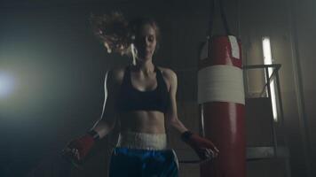 Close-up of jumping rope in a dark room with smoke with back light from the front, slow motion, 4k video