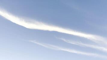 White lines after flying airplane in blue sky at summer sunny day. Beautiful cloudscape at background. Close up Slow motion photo