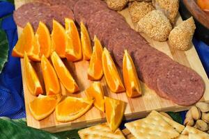 a cutting board with sliced oranges and crackers photo