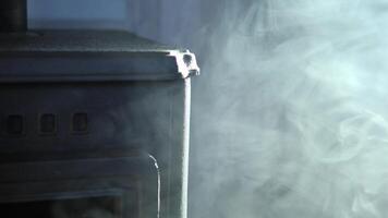 Dense white smoke billowing from malfunctioning cast iron stove, rapidly spreading across indoor space and creating dangerous household hazard with potential respiratory risks video