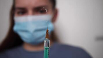 Medical professional wearing protective gear preparing vaccine injection with syringe in sterile hospital environment, focusing on precision and care while handling vaccine video