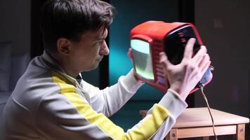 Furious Man shaking vintage red old television trying to fix reception problems video