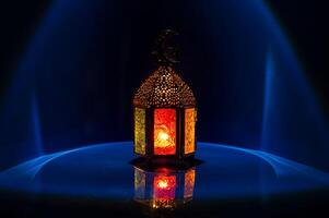 Lantern with moon symbol on top on dark blue background for the Muslim feast of the holy month of Ramadan Kareem. photo