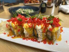 Delicious Sushi with salmon, panko tiger prawns, cucumber, unagi sauce, mayonnaise, sesame seeds in Japanese restaurant photo