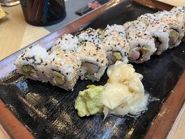 Close up sushi roll on black plate in Japanese restaurant photo