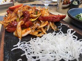 Close up of Sliced chicken fillet with hot garlic sauce with vegetables and fried glass noodle photo