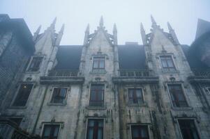 The facade of the building in the style of old European architecture in the fog photo