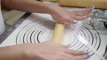 Hands rolling out gyoza dough on a floured surface with precision showcasing the process of crafting Japanese dumpling wrappers, with kitchen tools like a rolling pin and sifter in the background video