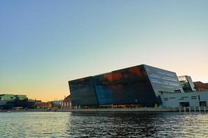 Exterior of Royal Library in Copenhagen. Facade of national library of Denmark known as the Black Diamond at sunset. Modern architecture in city photo